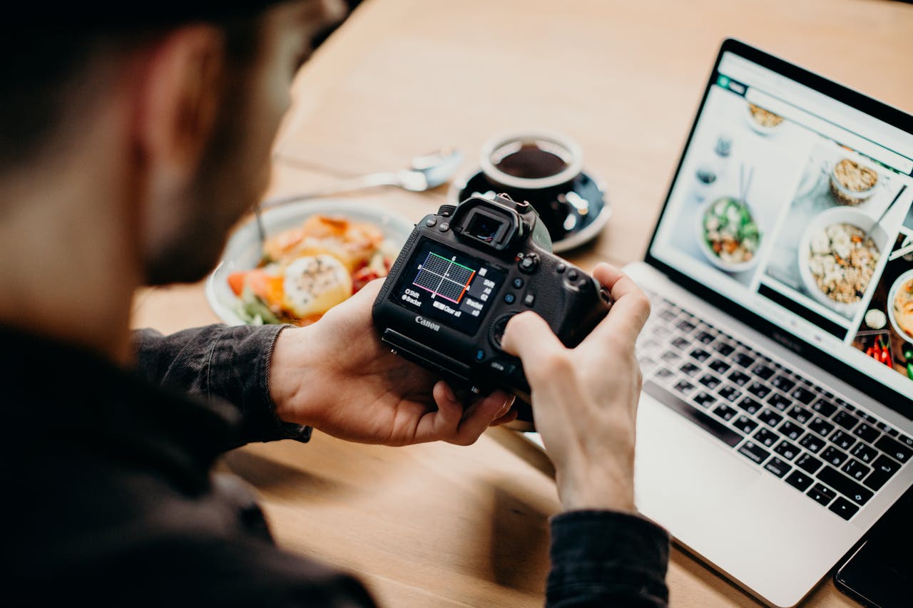 Man downloading photos from his camera onto his laptop.