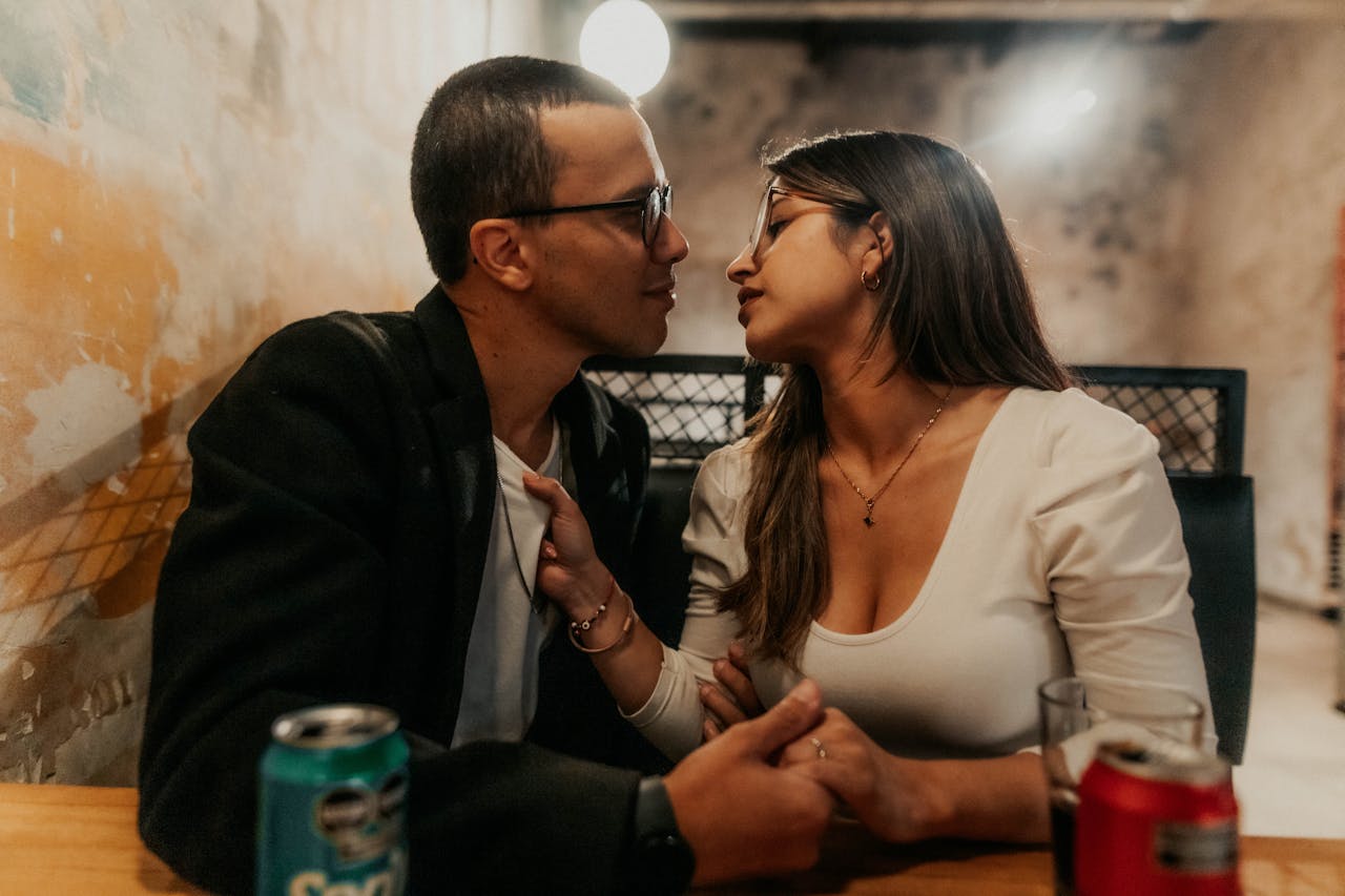 Young couple sitting at a table about to kiss