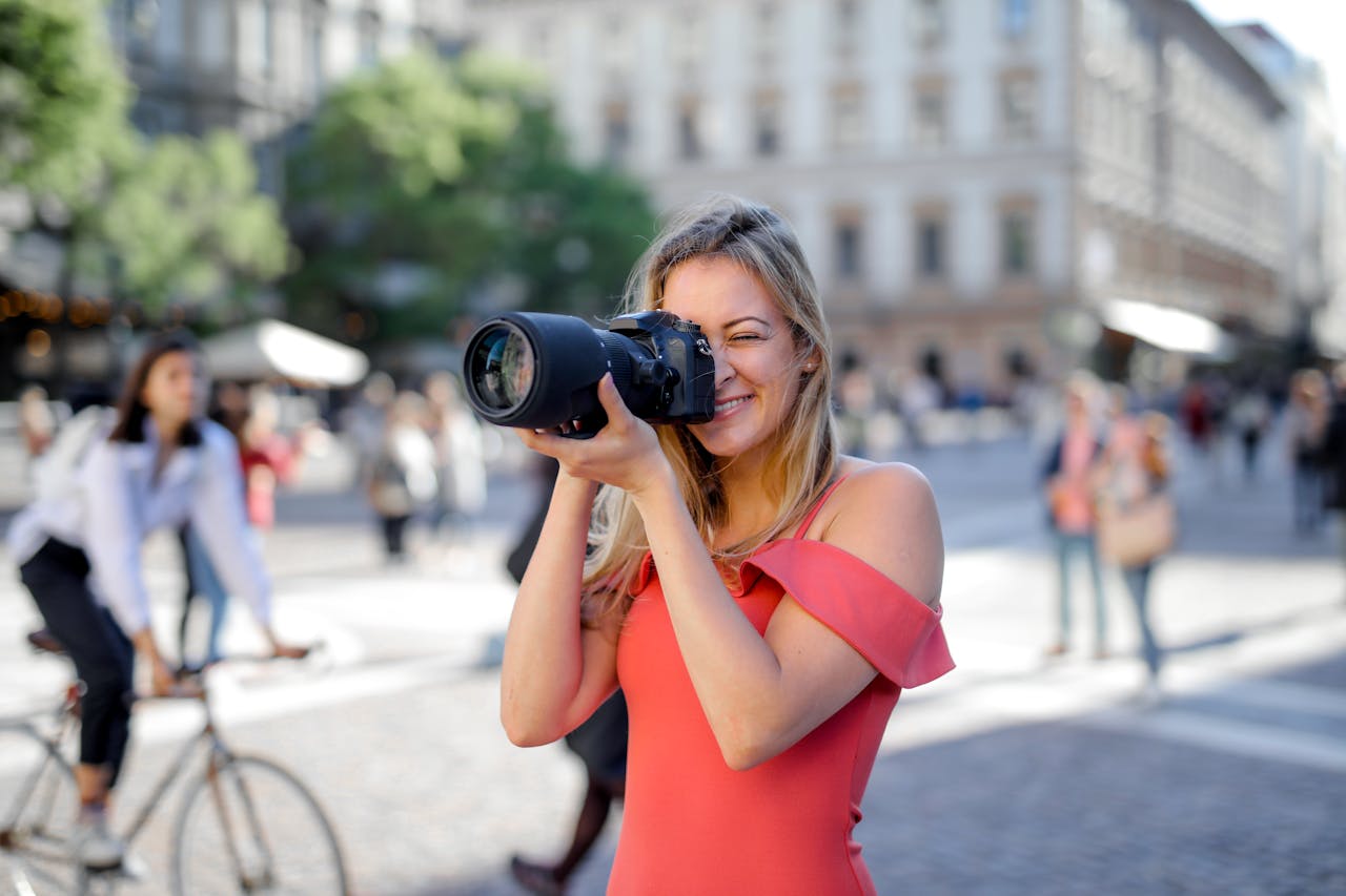 Photography example with lady taking pictures with her camera on a busy sidewalk