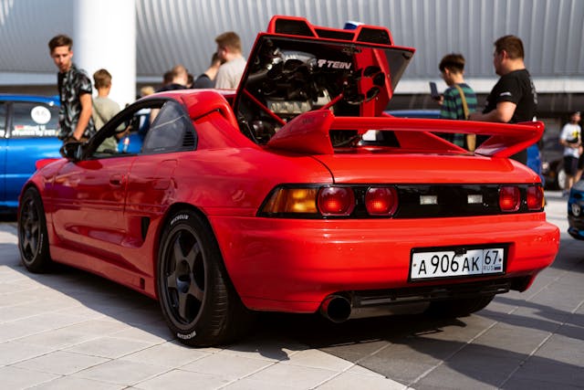 red car at a car show with spectators