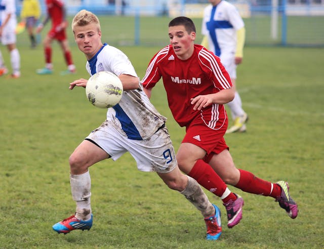 Two soccer players battling for possesion of the ball